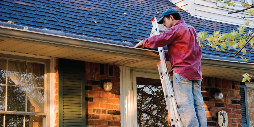 Man cleaning gutters